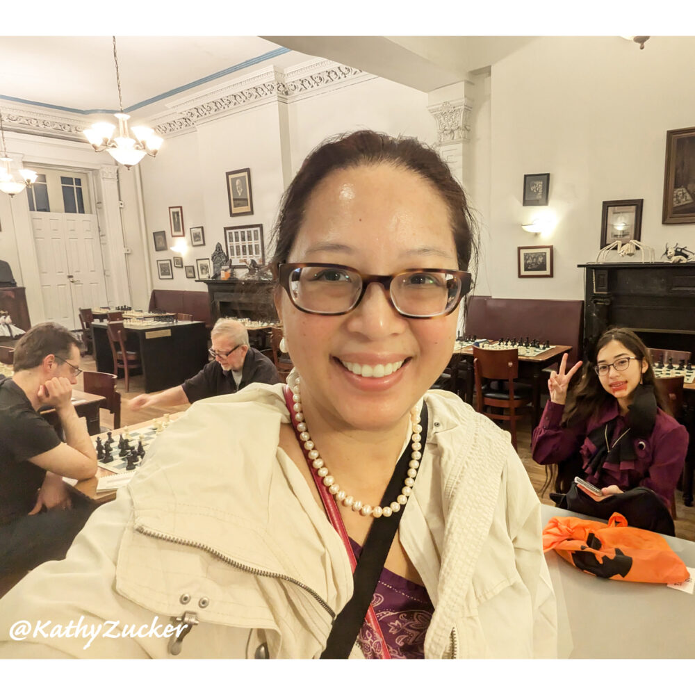 Asian woman standing in front of chess tournament