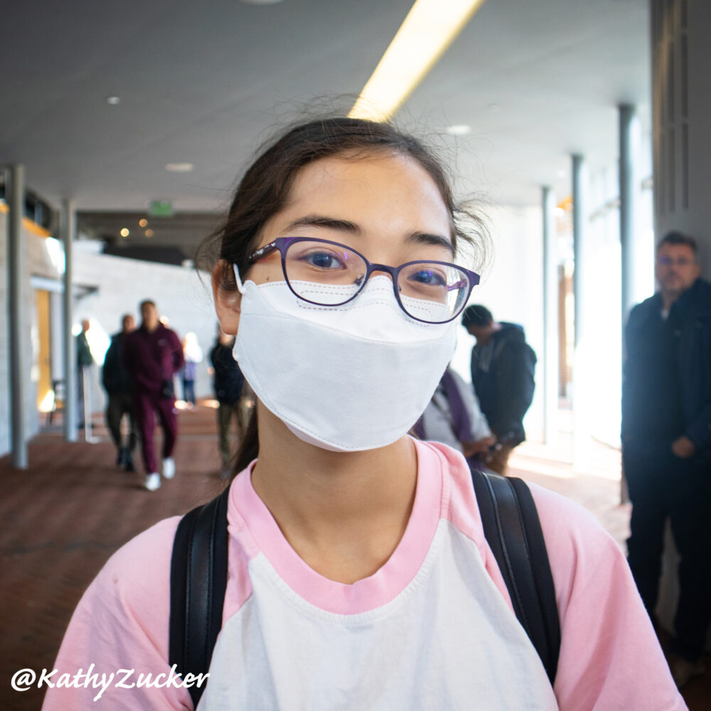 Young girl wearing a medical mask stands in the Liberty Center in Philadelphia, PA